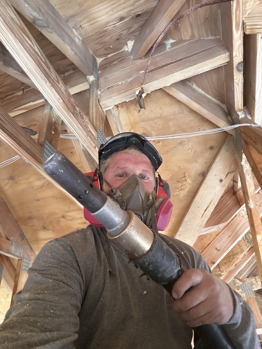Media blasting operator in a respirator holding the blast nozzle